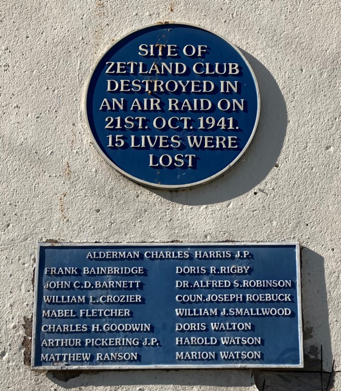 A blue commemorative plaque reading 'site of Zetland Club destroyed in an air raid on 21 Oct 1941. 15 lives were lost