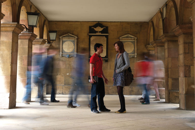 Students talking and walking in Chapel Cloisters