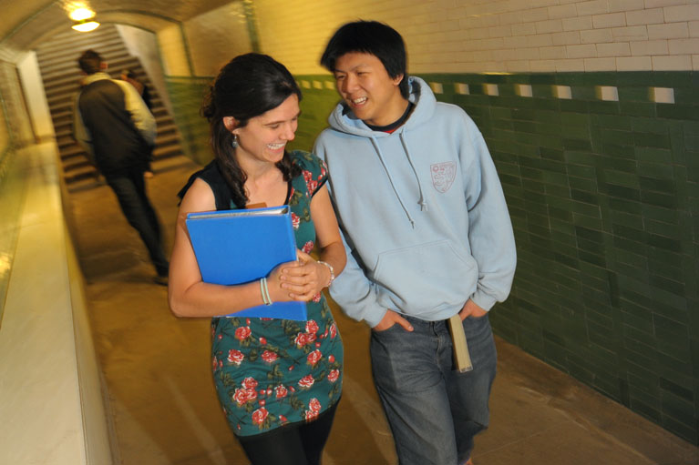 Undergraduates walking through the green and white tiled tunnel