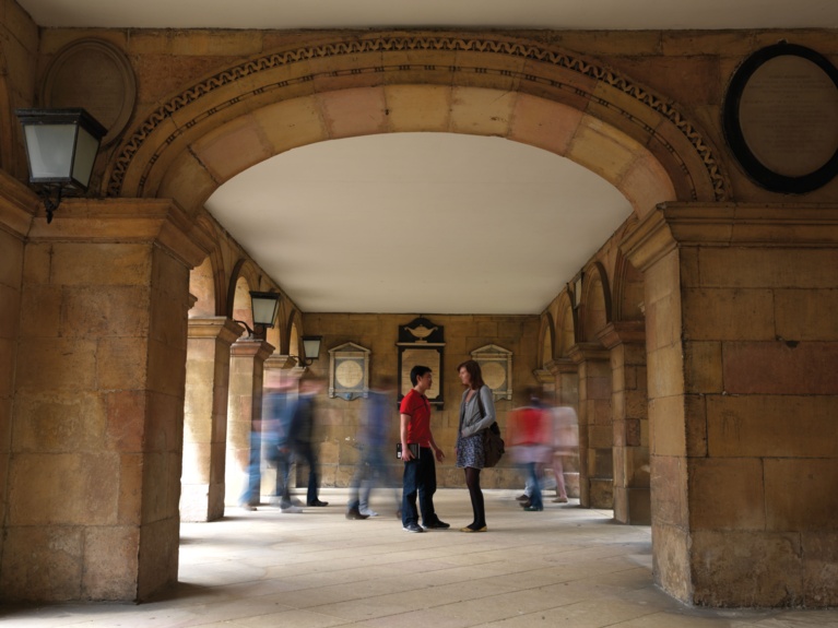 Students talking and walking in Chapel Cloisters