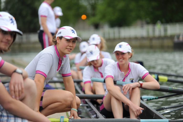 College Boat on the river bank with students looking at the camera